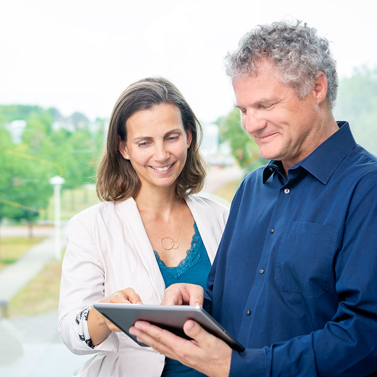 Coach und Coachee schauen auf Tablet