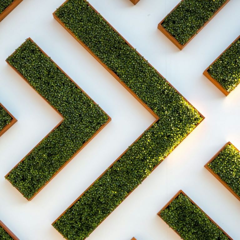 Grünes Labyrinth bildet Pfeil in Richtung ESG-Transformation